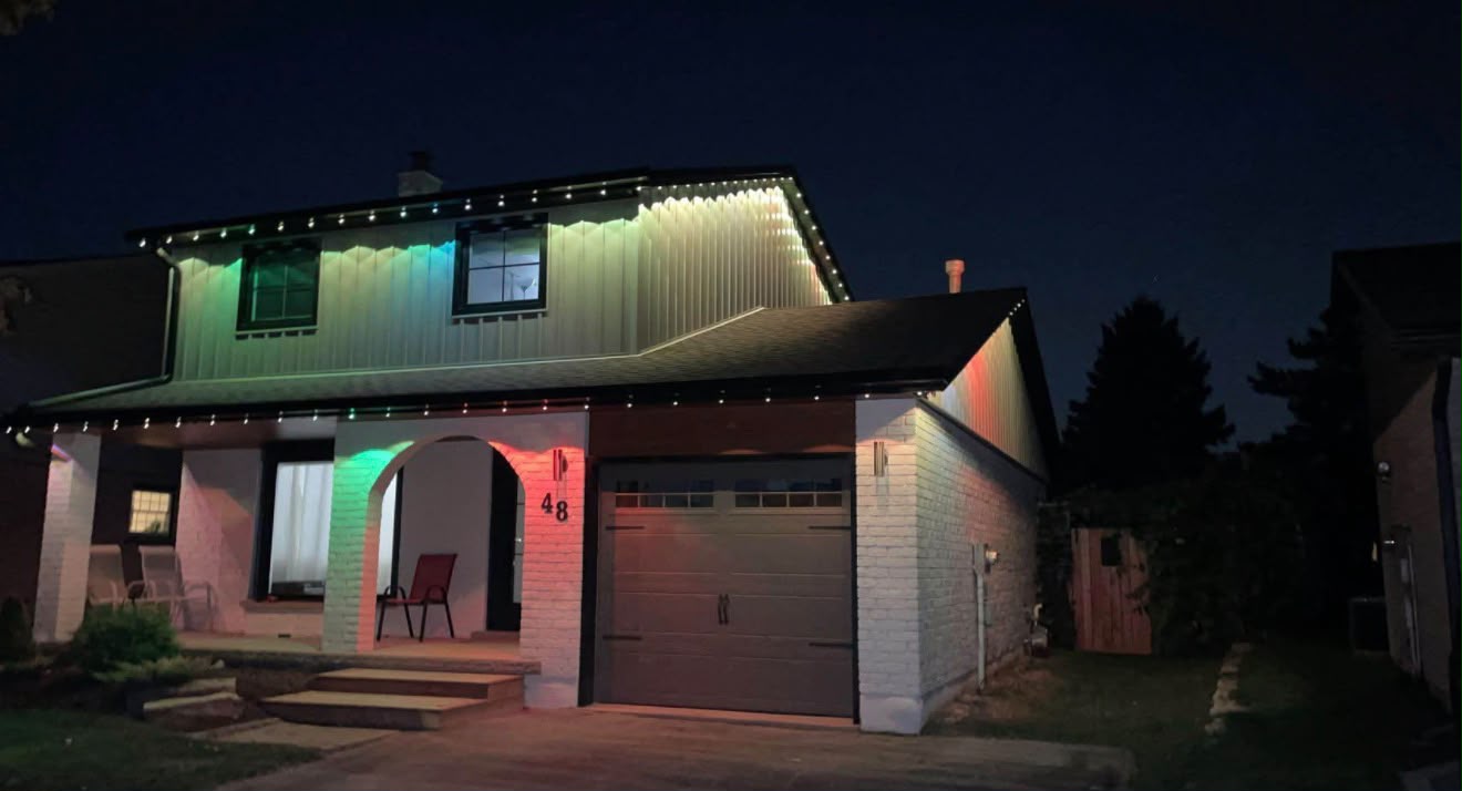 Bungalow at night with a multicolour light line along the roof edge and porch